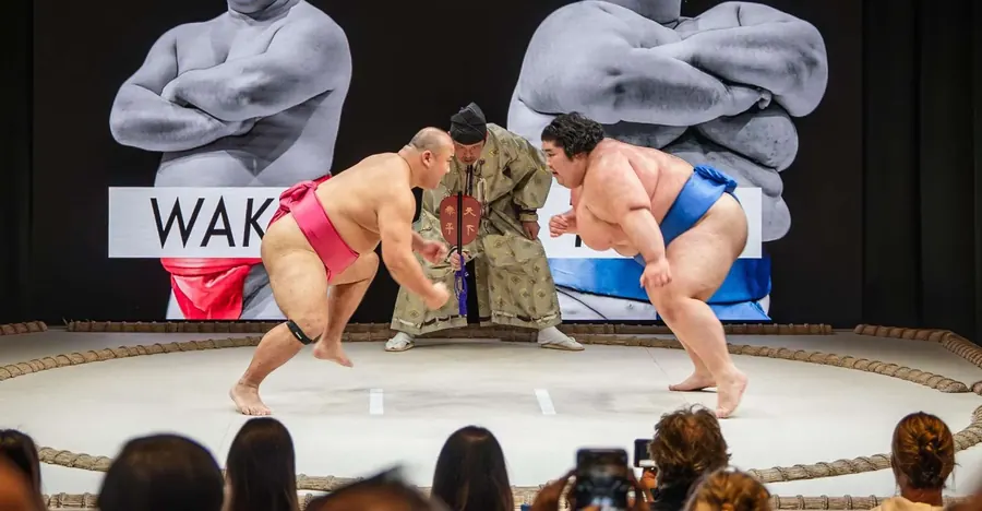 Live sumo show at Sumo Hall Hirakuza Osaka — retired wrestlers on stage with audience participation and photo opportunity